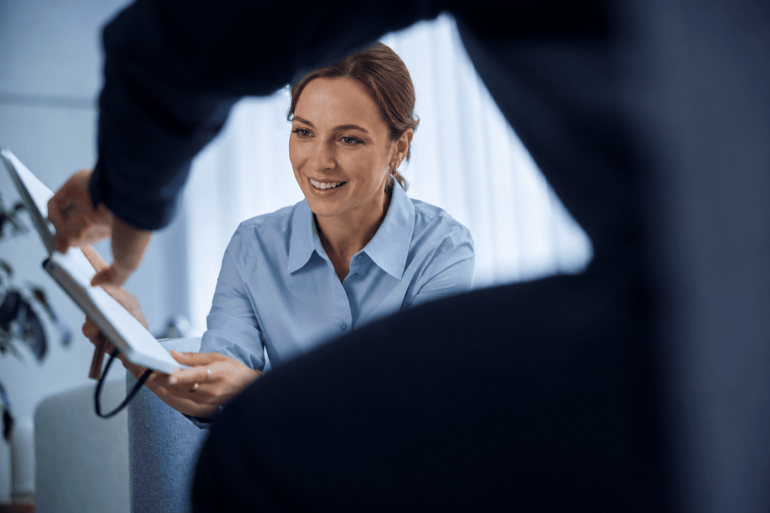 Front desk staff handing paperwork to a patient